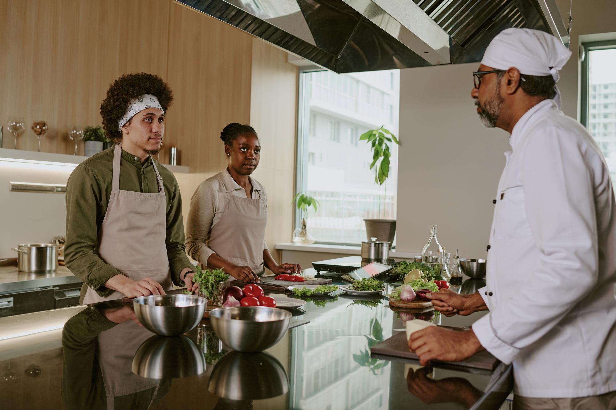 Chefs collaborating around bench